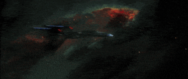a space ship is flying through a nebula with a red glowing object in the background