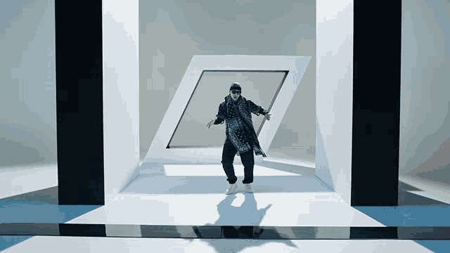 a man in a black and white outfit is dancing in a room