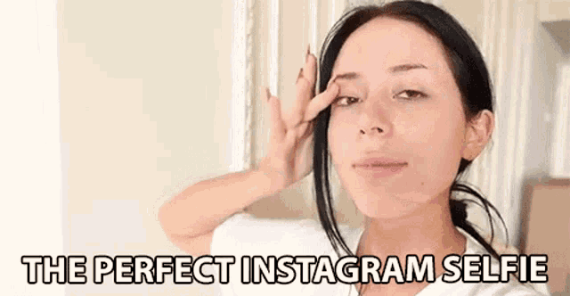 a woman without makeup is taking a selfie with her hand on her forehead .