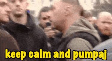 a man speaking into a microphone in a crowd with the words keep calm and pumpaj below him