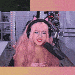 a woman with pink hair wearing headphones and a cat ear headband