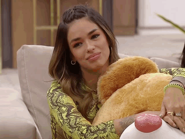 a woman sitting on a couch with a teddy bear in her lap