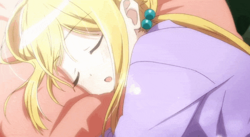 a girl with blonde hair is sleeping on a bed