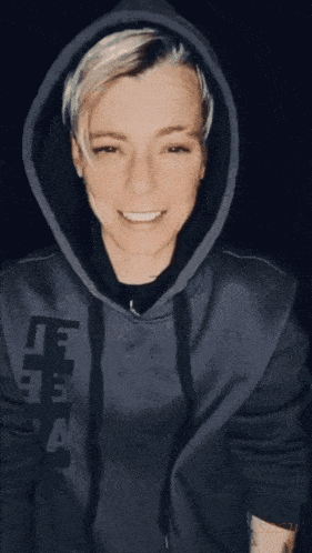 a woman wearing a hoodie with the letter a on the front