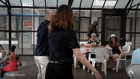 a group of people are standing around a table in a greenhouse .