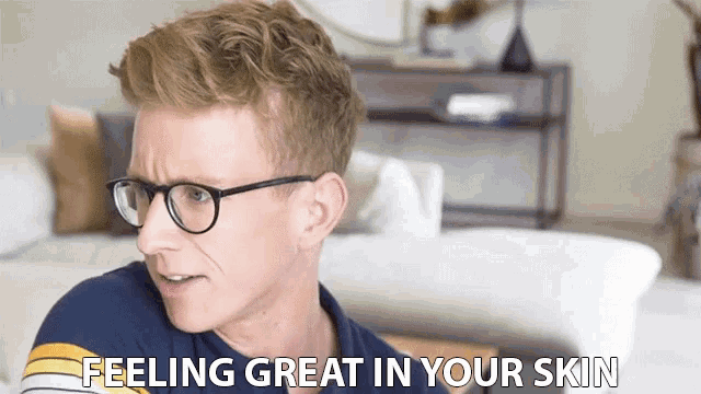 a man wearing glasses and a blue shirt says feeling great in your skin