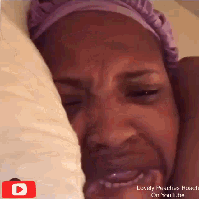 a woman with a purple headband is crying with a youtube logo in the corner