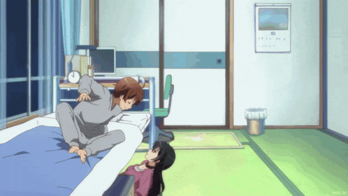 a girl laying on a bed with a man sitting on top of her
