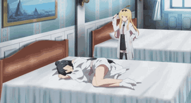 a girl is laying on a bed while another girl stands in the background