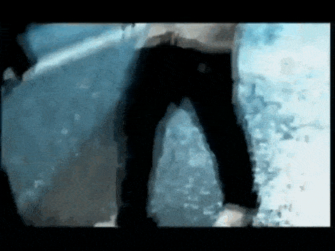 a man in black jeans is standing next to a wall in the water .