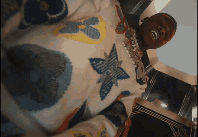a man wearing a louis vuitton sweater is laying down
