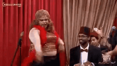 a man and a woman are dancing on a stage in front of a microphone .