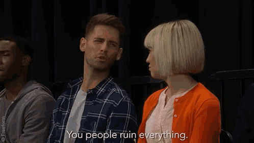 a man and a woman are sitting next to each other and the woman is saying " you people ruin everything " .