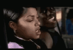 a man and a woman are sitting in a car and the woman is blowing a kiss