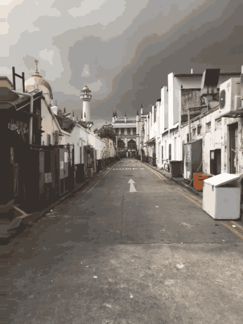 a street with an arrow pointing to the right and a mosque in the background