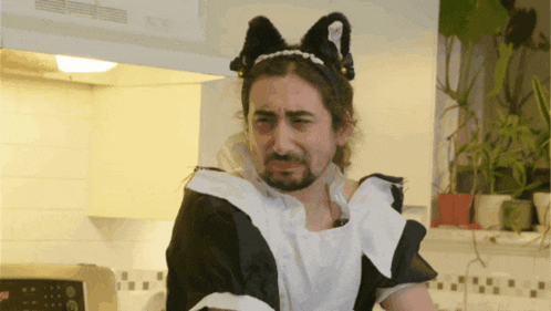 a man is wearing a maid outfit and a cat headband