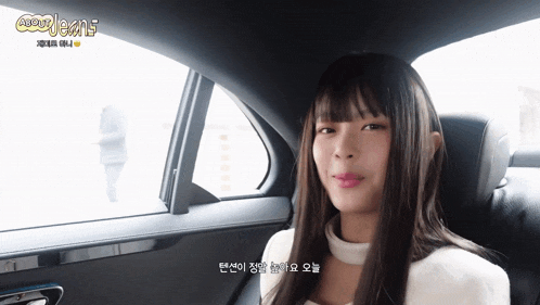 a woman sitting in the back seat of a car with a foreign language written on the bottom