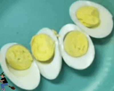 three hard boiled eggs on a blue plate with a witch on a broom