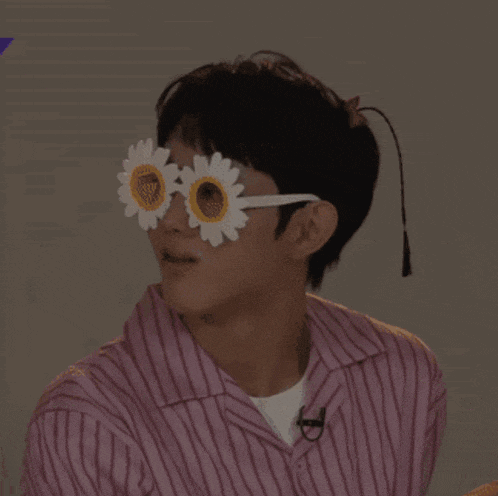 a man wearing a pink striped shirt and flower sunglasses