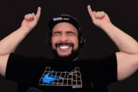 a man with a beard wearing headphones and a nike shirt is raising his arms in the air