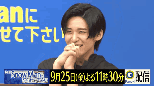 a man is smiling in front of a blue background that says snow man