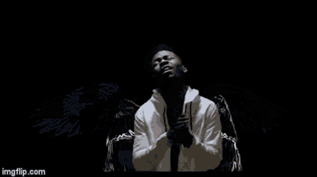 a man with angel wings is holding a microphone