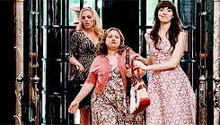 three women are standing next to each other in front of an elevator .