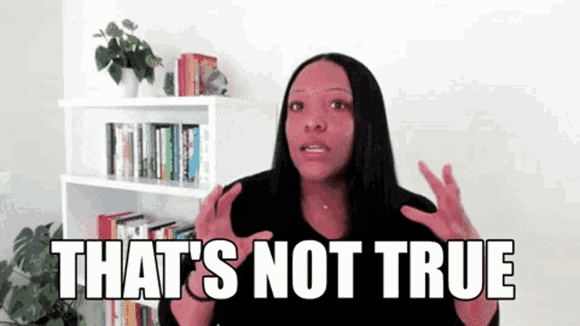 a woman is saying that 's not true in front of a bookshelf filled with books .