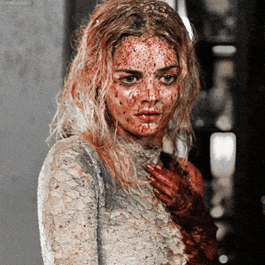 a woman with blood on her face is wearing a white lace shirt