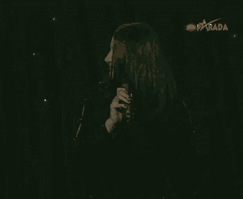 a woman singing into a microphone with the word jebiga in white