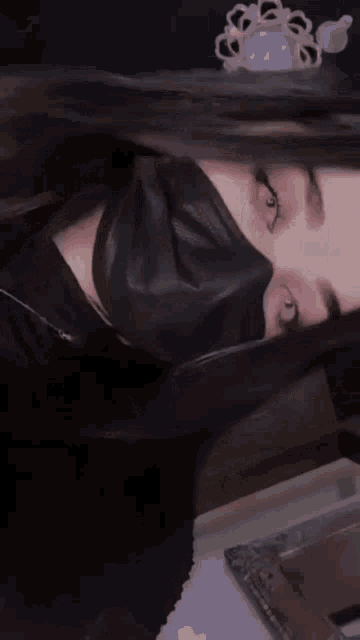 a woman wearing a black mask on her face .