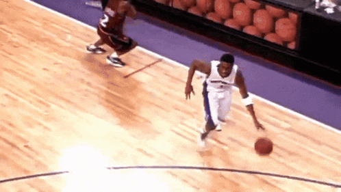 a basketball player with the number 2 on his jersey is dribbling a basketball
