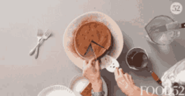 a person is cutting a chocolate cake on a plate with the number 52 on the bottom right