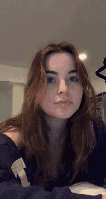 a young woman wearing a black sweatshirt with the letter r on it