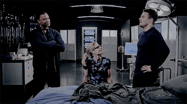 a man and a woman are standing next to a bed