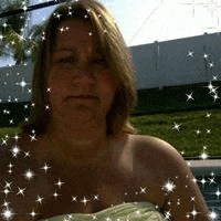 a woman is taking a picture of herself in front of a pool with a white fence in the background .