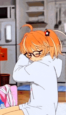 a girl with orange hair and glasses is sitting at a table .