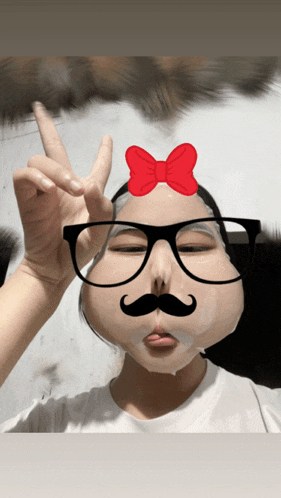 a girl wearing glasses and a fake mustache is giving a peace sign