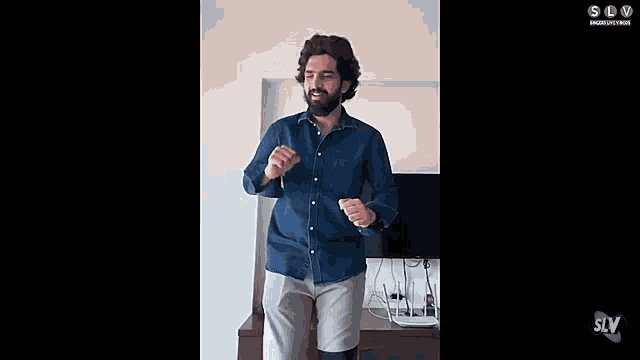 a man is dancing in a living room in front of a television .