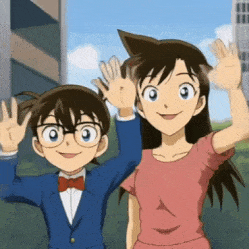 a boy and a girl are standing next to each other and waving at the camera .