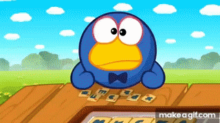 a blue cartoon character with a bow tie is sitting at a table with cards .