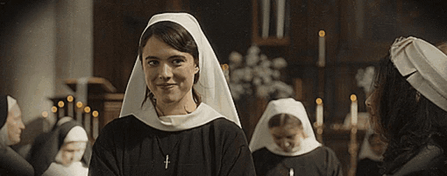 a woman in a nun 's veil has a cross on her necklace