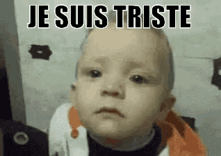 a baby with a sad look on his face and the words `` je suis triste '' written above him .