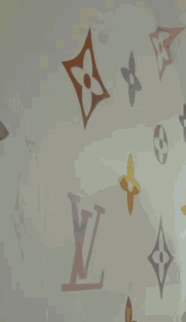 a man wearing an orange hat and a white t-shirt is standing in front of a wall with louis vuitton logos