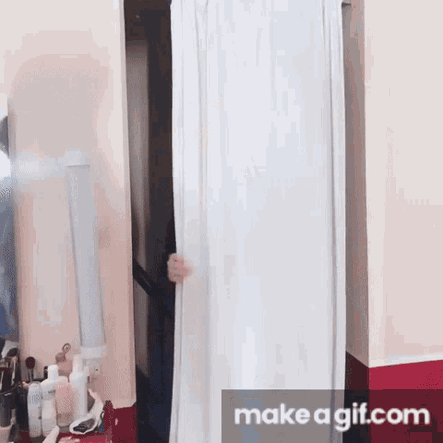 a person is hiding behind a white curtain with make a gif.com written on the bottom