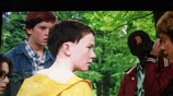 a boy in a yellow shirt is standing in a group of people
