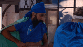 a man with a beard is wearing a blue turban and a blue shirt with a star on it