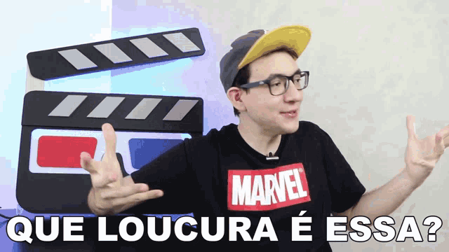 a man wearing a marvel t-shirt is pointing at something