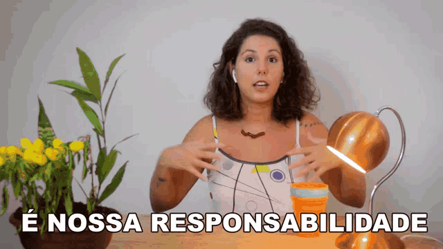 a woman stands in front of a plant and a lamp with the words " e nossa responsabilidade " written above her