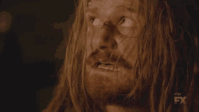 a close up of a man 's face with a fx logo in the corner